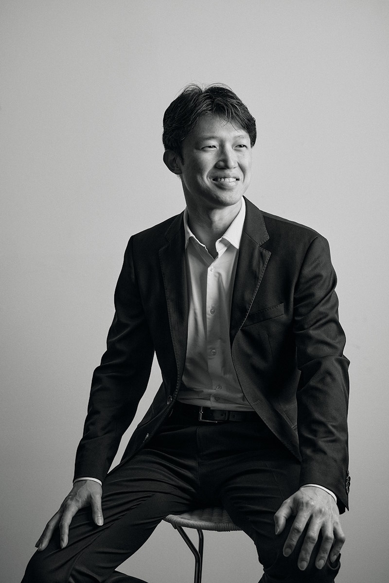 Profile of Terence Tan sitting on a chair.